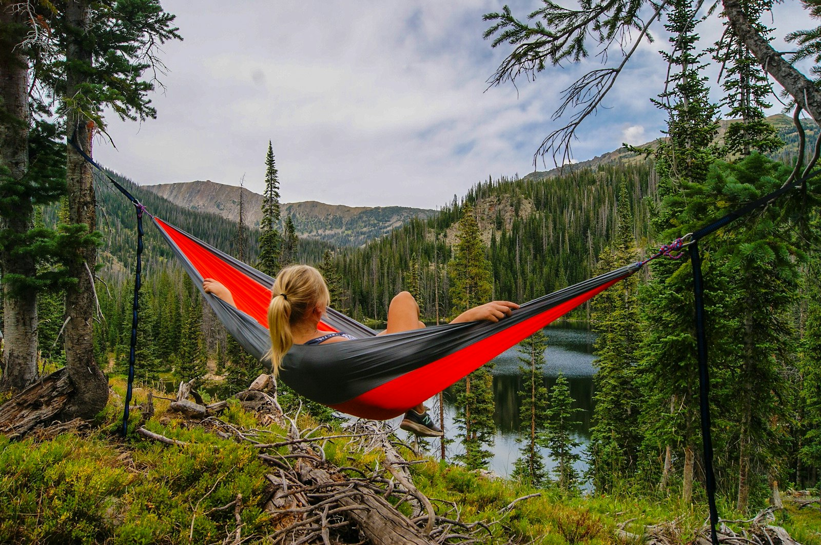 Traveler relaxing in a hammock by a lake